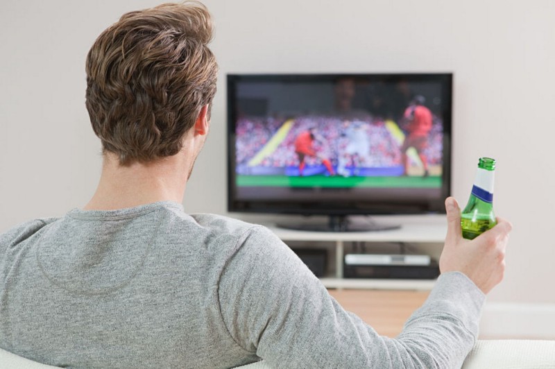 Muž pozerá futbal v TV (mirror.co.uk)